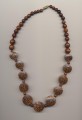 A missing bead in a necklace made of flat palm wood and other wooden beads on plastic monofilament beading thread (so called fishing line), length 22'' 56cm.